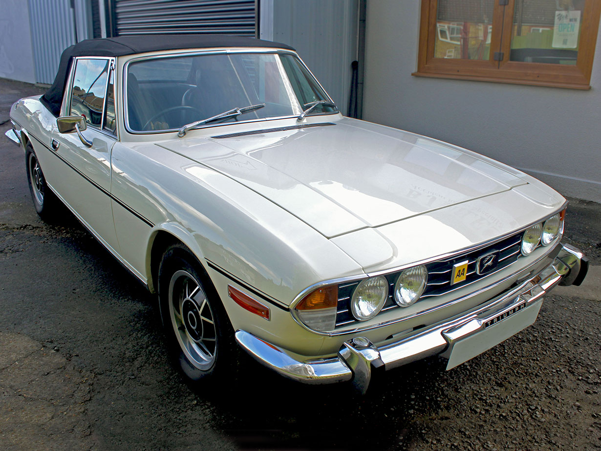 Fully restored cream Triumph Stag outside B J Miles Workshop
